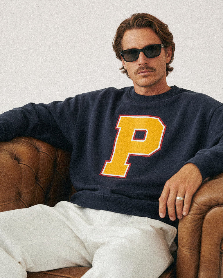 Adult wearing a Baron & Buck varsity monogram sweatshirt in navy, showcasing a timeless collegiate silhouette designed for modern family wear.