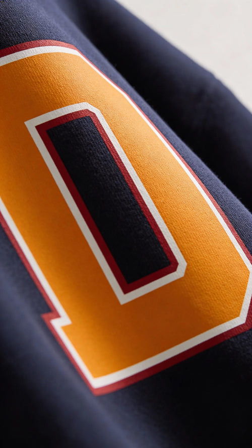 Close-up of varsity monogram letter D print on French Navy cotton sweatshirt