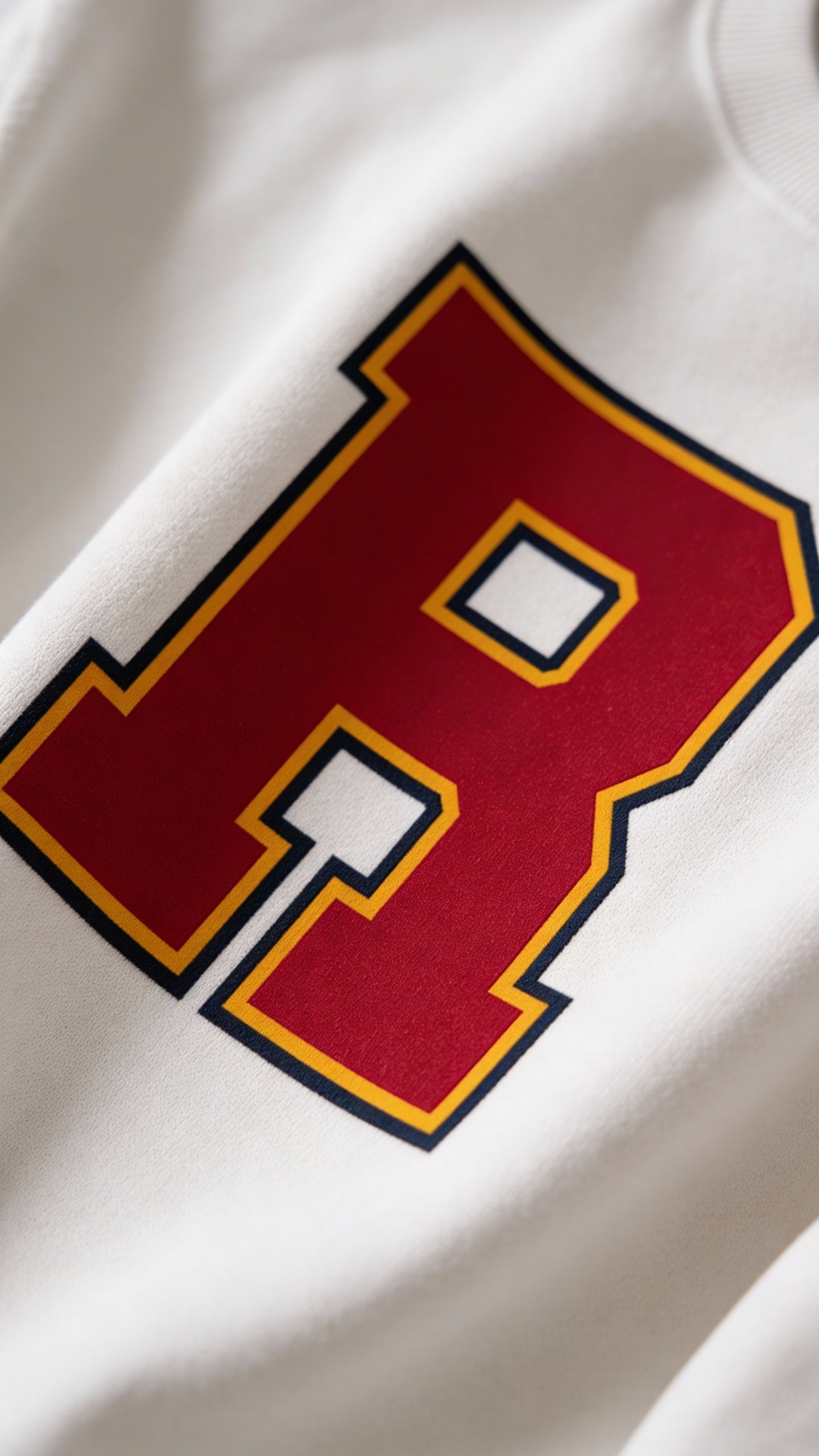 Close-up of varsity monogram letter R print on White cotton sweatshirt