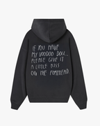 Back view of Baron & Buck ash hoodie featuring handwritten white text that reads, “If you have my voodoo doll, please give it a little kiss on the forehead” — a soft, poetic streetwear statement.
