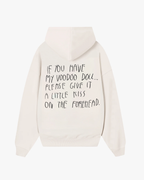 Back view of Baron & Buck Marshmallow hoodie featuring handwritten black text that reads, “If you have my voodoo doll, please give it a little kiss on the forehead” — a soft, poetic streetwear statement.